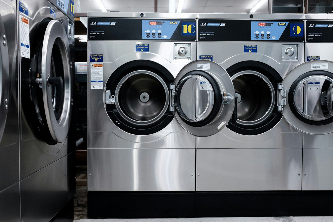 Row of front-loading washing machines in a laundromat
