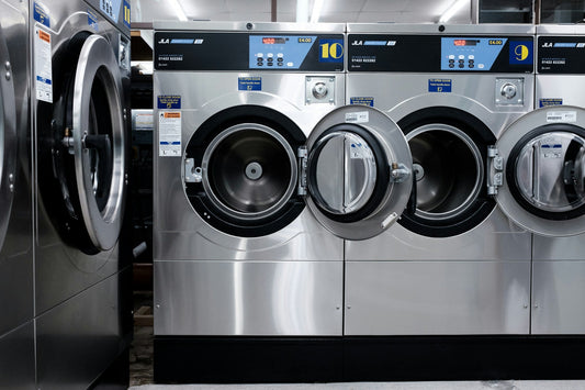 Row of front-loading washing machines in a laundromat