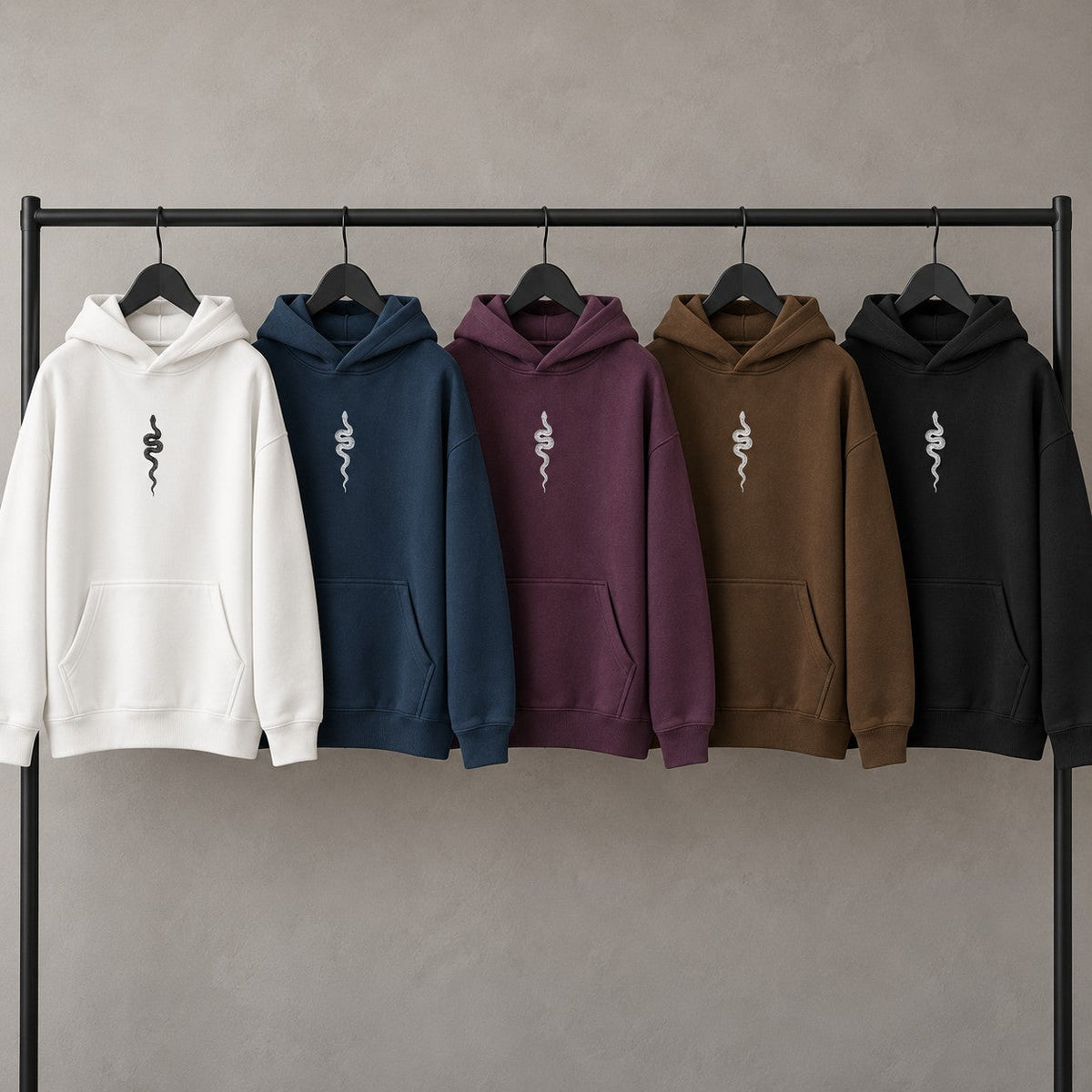 Five Ranked hoodies on a rack in belt order: white, blue, purple, brown and black