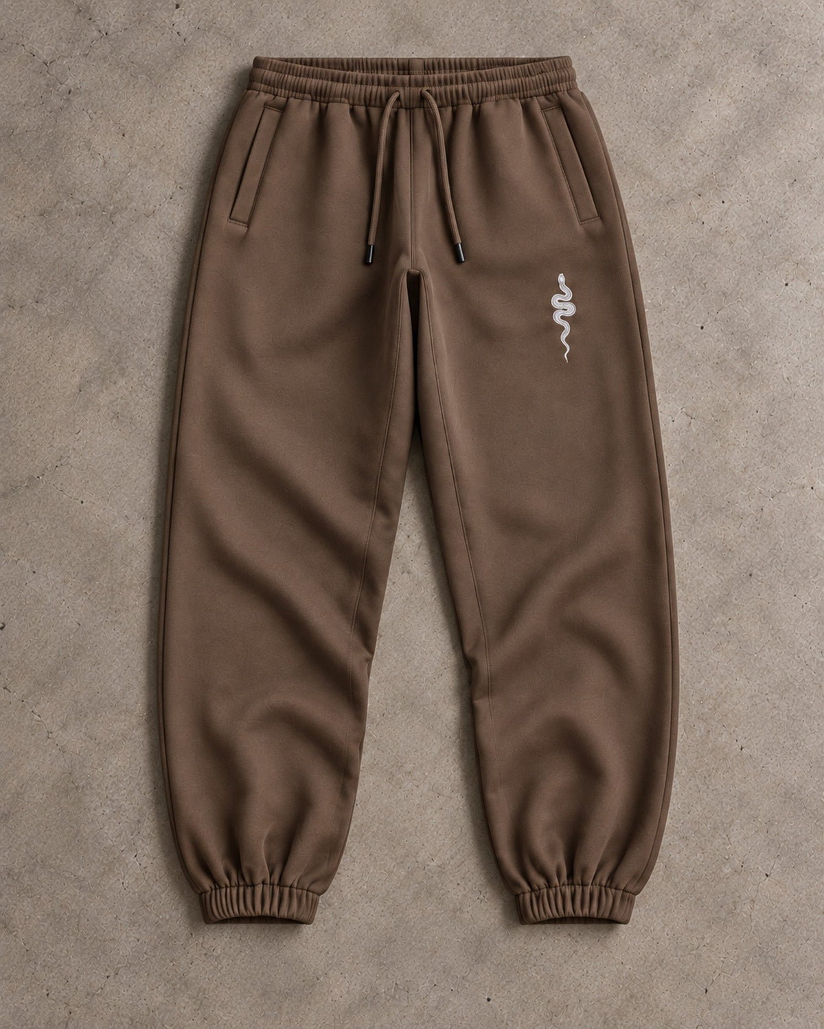 Ranked Brown Heavyweight Joggers laid flat on concrete